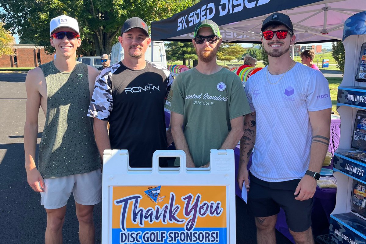 Winners of the tournament stand for a photo by the sponsorship sign.